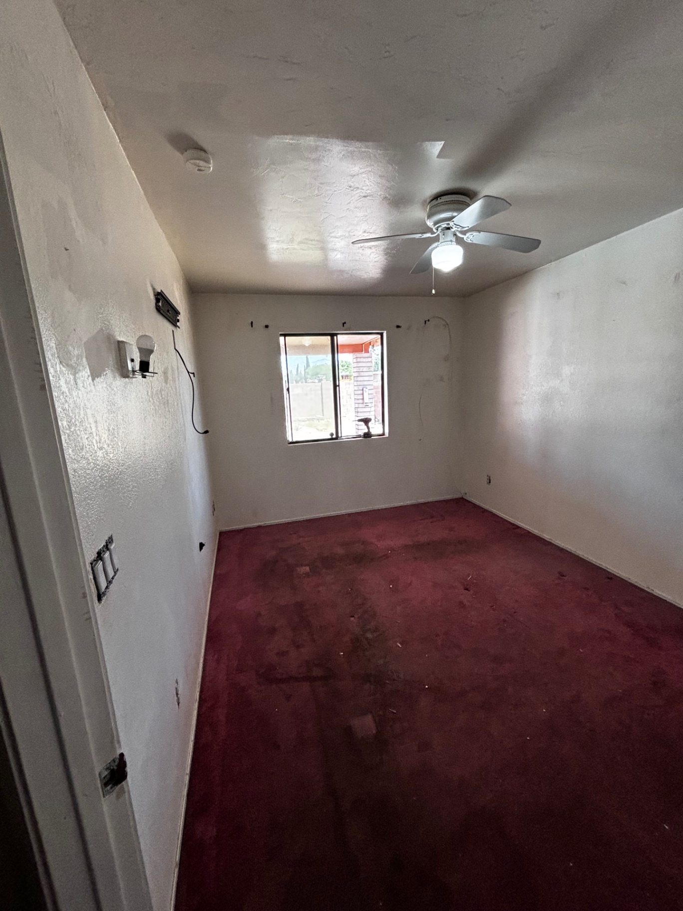 Bedroom before — old red carpet and bare walls