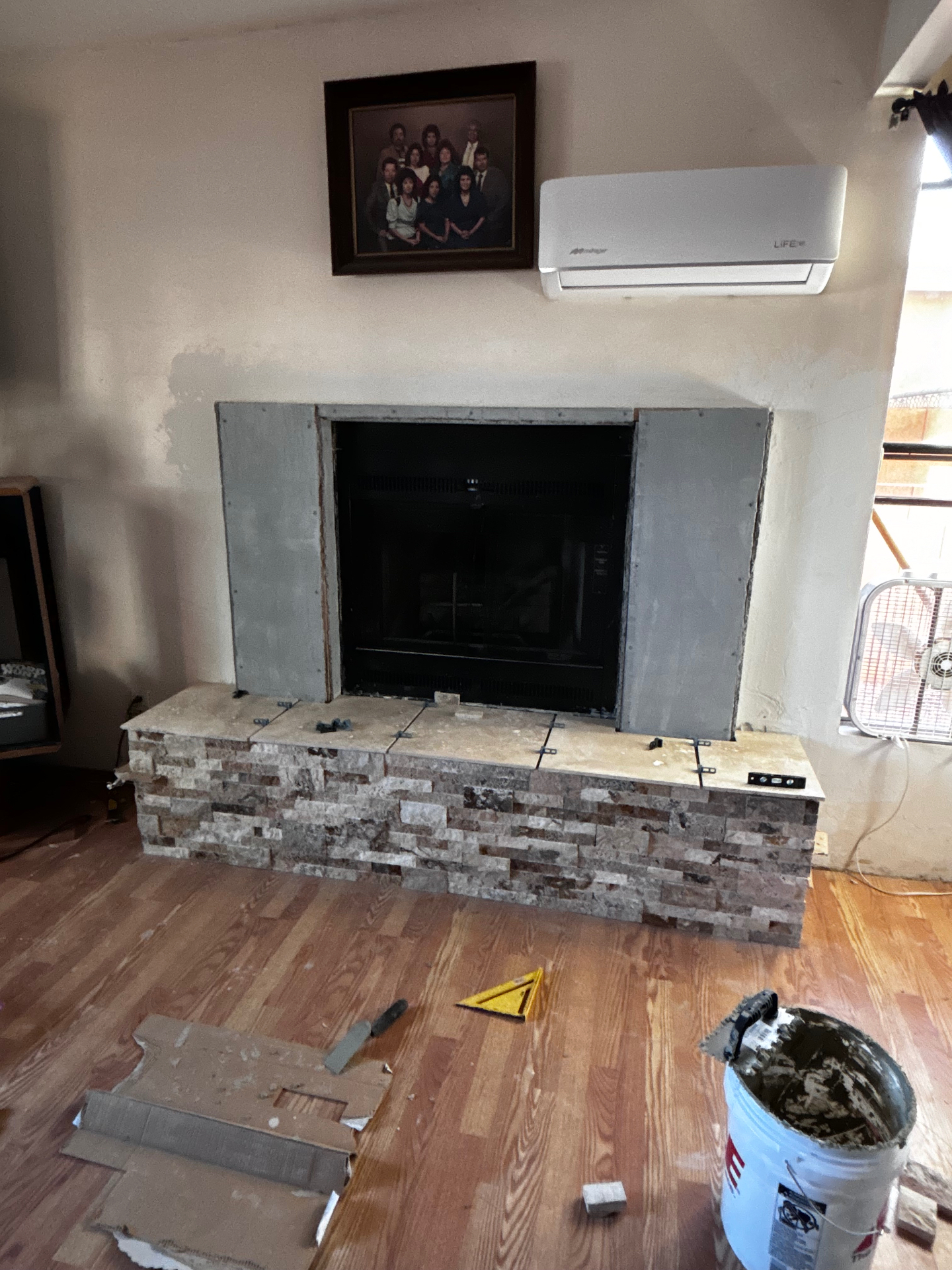 Existing fireplace with new stone install in progress