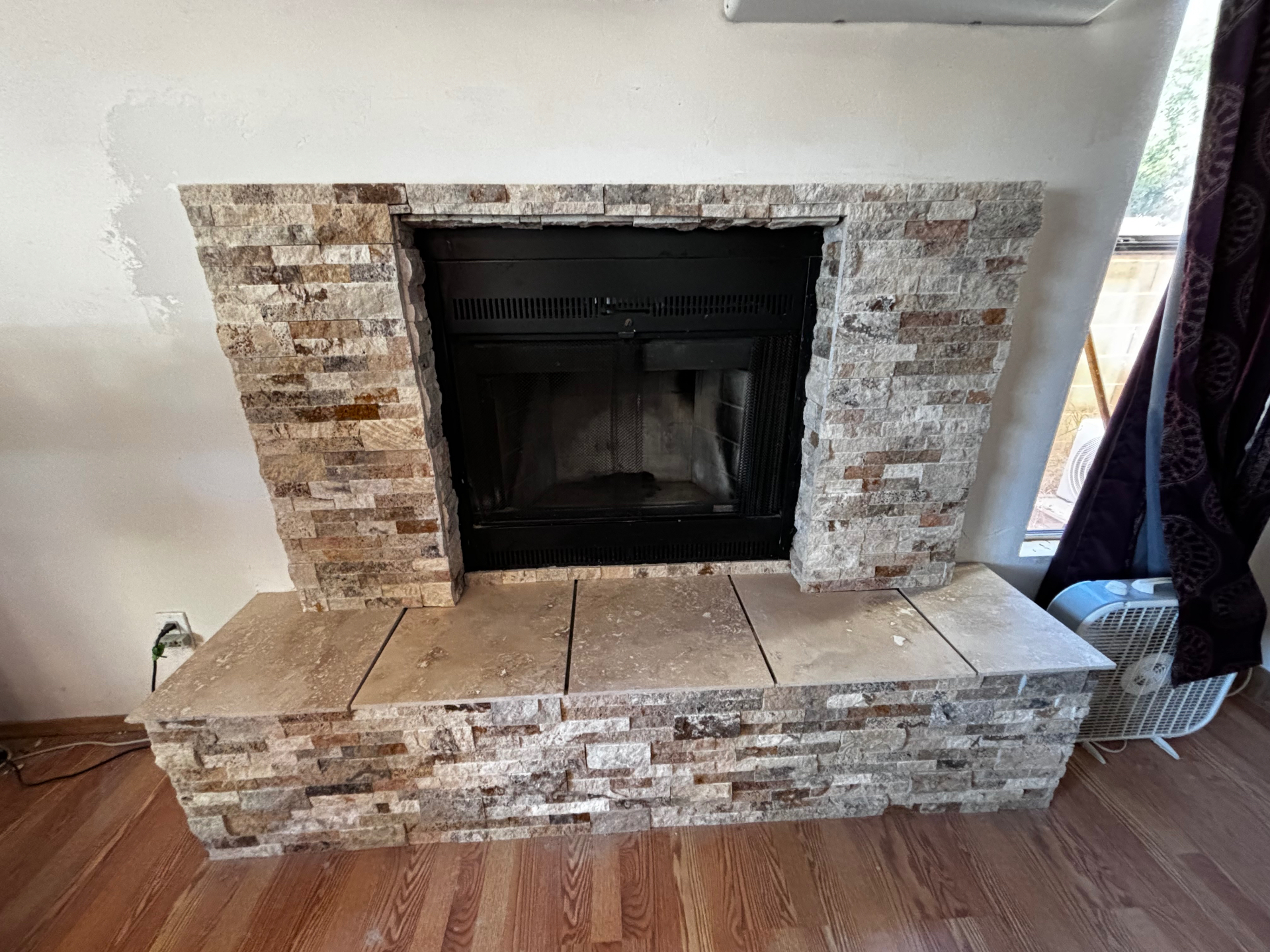 Remodeled fireplace with finished stacked stone surround