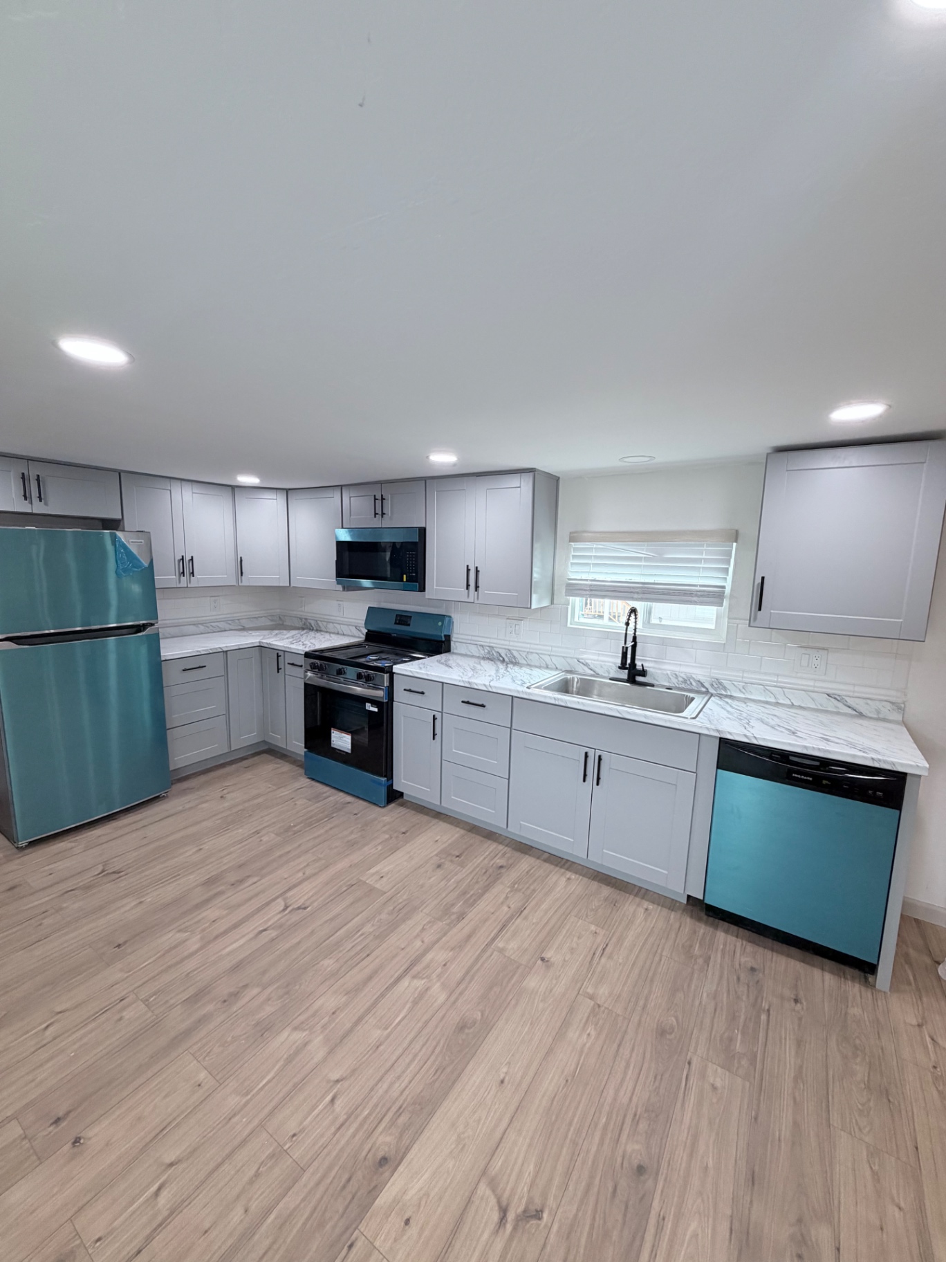 Finished kitchen with LVP flooring and appliances
