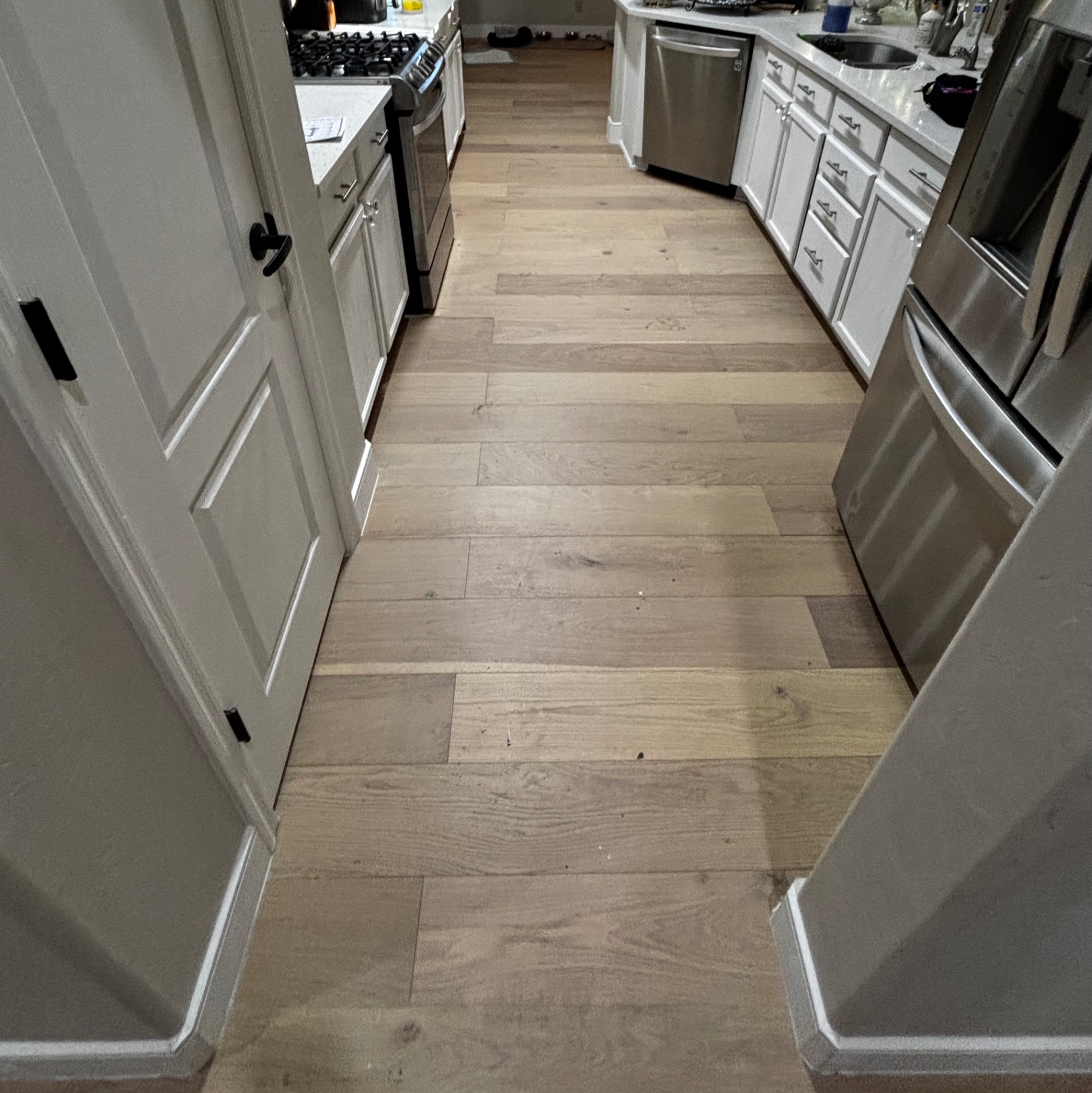 Finished hardwood flooring through kitchen with appliances