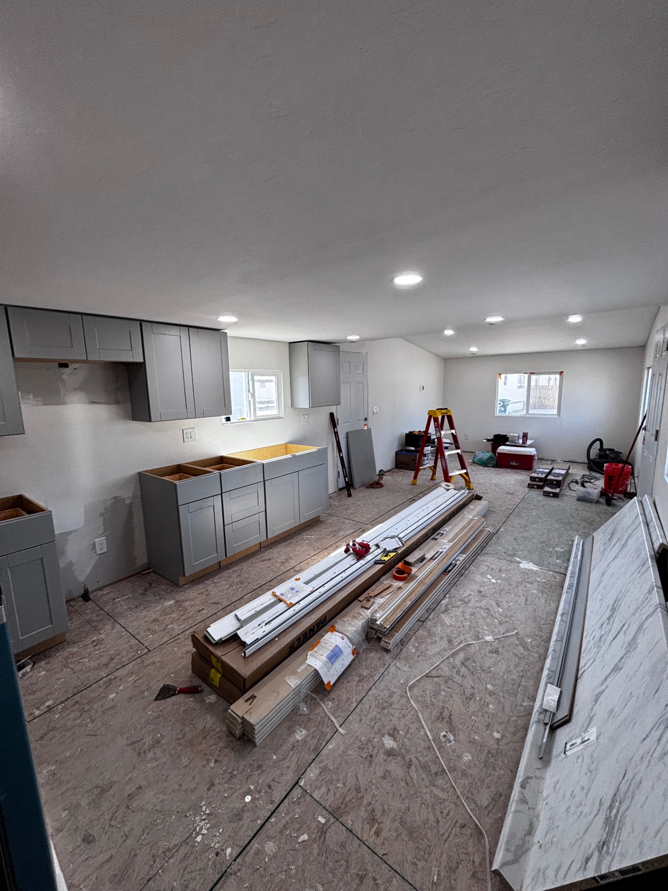 Wide view of cabinets in progress with materials staged